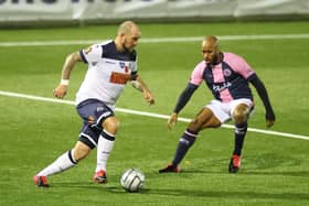Hawks' Danny Kedwell takes on Dulwich Hamlet's Sanchez Ming last November. While Hawks banked £90,000 in National Lottery cash between October and December, Dulwich were handed £108,000 for the same period. Picture by Dave Haines.