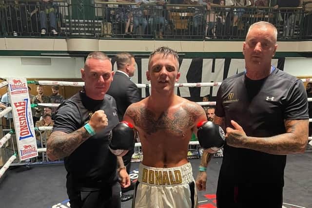 Bailey Donald, centre, with trainer Daron Wiseman, right, plus father and assistant coach Adrian Donald