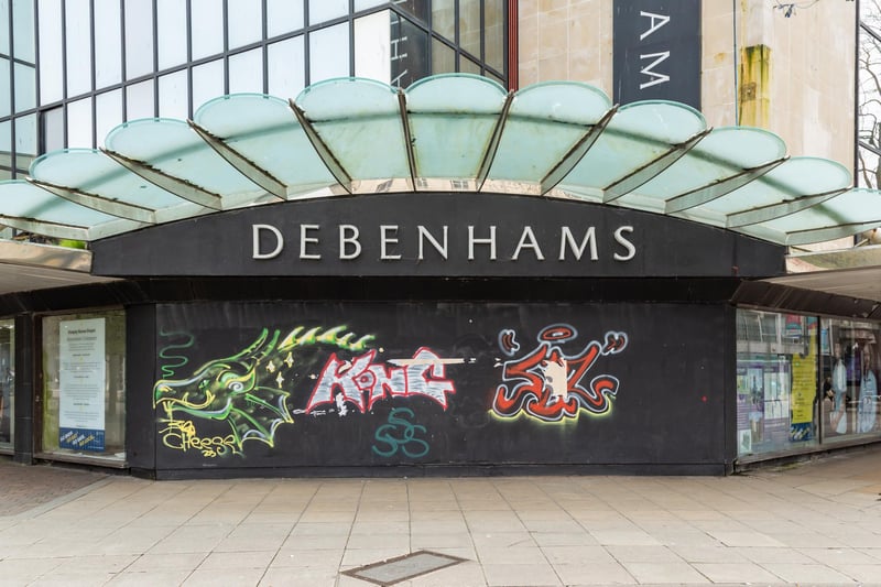 Graffiti-covered boards across the entrance to the former Debenhams shop in Arundel Street