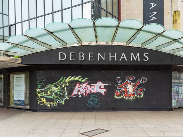 Graffiti-covered boards across the entrance to the former Debenhams shop in Arundel Street