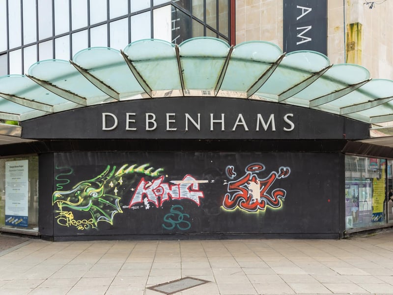 Graffiti-covered boards across the entrance to the former Debenhams shop in Arundel Street