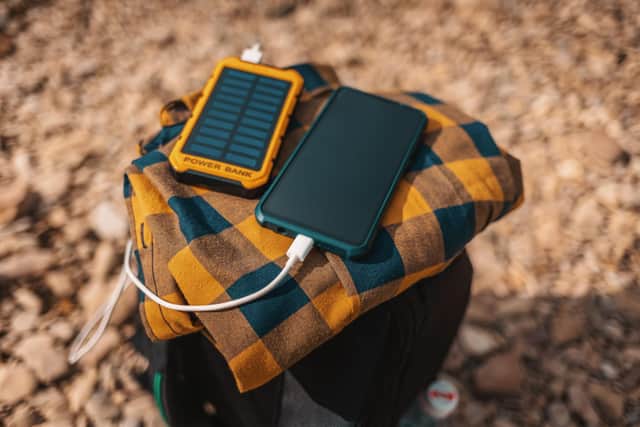 Solar power bank charges the smartphone. Photo: Adobe