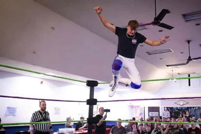 Wrestler Noah Hames delivering a knee drop.