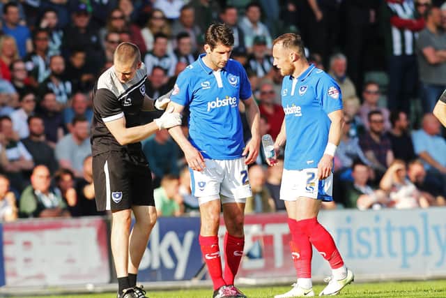 Pompey physio Sean Duggan assists Danny Hollands after suffering an ankle injury in the second leg of Pompey's play-off semi-final against Plymouth in May 2015. Picture: Joe Pepler