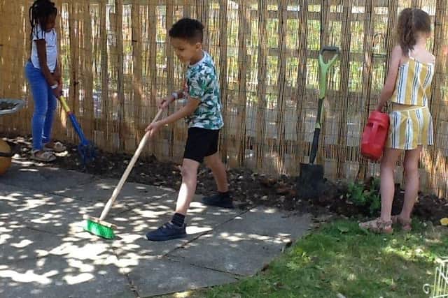 (Right to left) Patti Mutswiri, Evan Ayantoye and Violet Latimer, all six, help out in the school's new sensory garden.