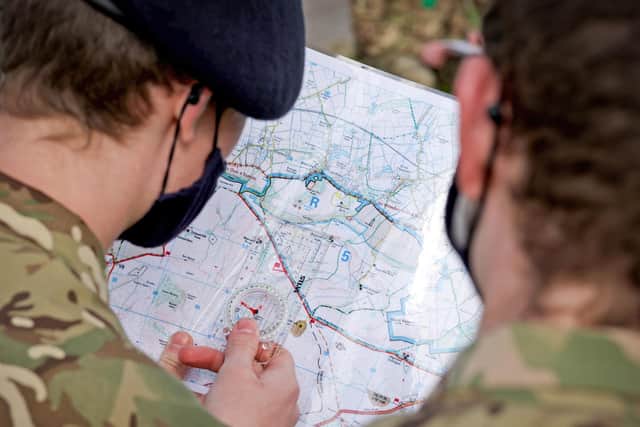 Trainees from HMS Collingwood get to grips with a compass and map during the training drill on Salisbury Plains. Photo: LPhot Rory Arnold