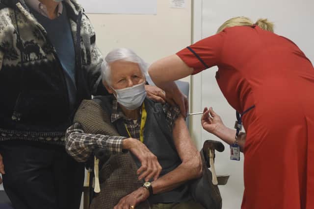 PORTSMOUTH, ENGLAND - DECEMBER 08: Michael Tibbs, 99, being administered the Pfizer/BioNtech covid-19 vaccine by Liz Rix, Chief Nurse at Queen Alexandra Hospital.  (Photo by Ewan Galvin - Pool / Getty Images)
