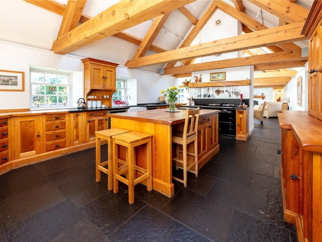 The open plan kitchen boasts timber from Douglas Fir trees from within the grounds, which have been used to create striking exposed cross beams. The kitchen itself is handcrafted from oak, also from within the estate