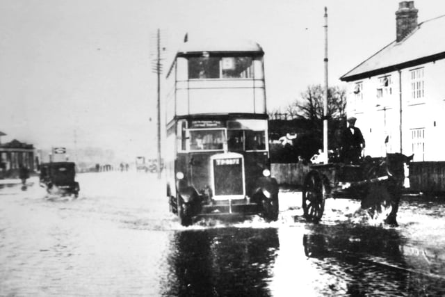 Ploughing through flood water at Hilsea, a bus travels south leaving a wake.