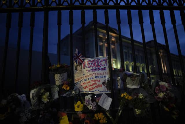 Mourners left flowers and messages for Queen Elizabeth outside Buckingham Palace in London, Friday, Sept. 9, 2022. (AP Photo/Christophe Ena)