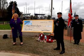 Team Scrubbers have raised £5,000 for the Royal British Legion through selling poppy face masks. Pictured: Lin Gell handing over the cheque