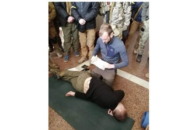 Shane Matthew pictured showing Ukrainian defence forces how to apply a bandage during a training session in Kyiv.