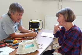 Fixer Andy, from one of the repair cafe branches, discussing a repair on an iron.