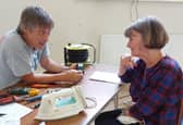 Fixer Andy, from one of the repair cafe branches, discussing a repair on an iron.
