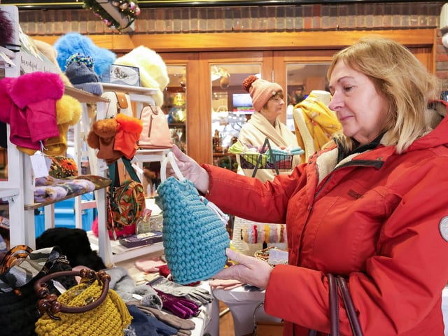 Linda Williams admires bags and hats on the Mad Bag Lady stall. Port Solent Christmas Market, Portsmouth
Picture: Chris Moorhouse (071224-15)