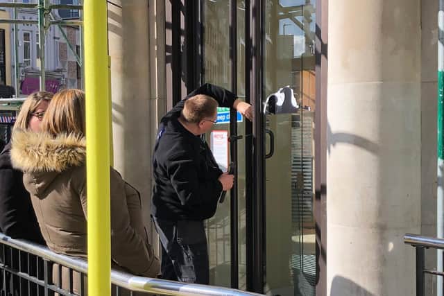 Customers and staff outsdie Barclays in Commercial Road, Portsmouth, where Greenpeace activists have drilled out the locks. A locksmith is trying to re-open the doors. Picture: Richard Lemmer