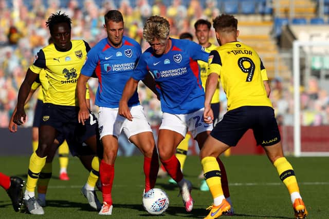 Cameron McGeehan is challenged by Matty Taylor of Oxford United