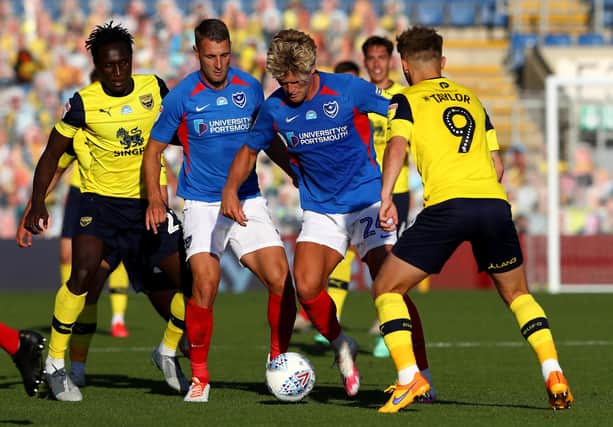 Cameron McGeehan is challenged by Matty Taylor of Oxford United