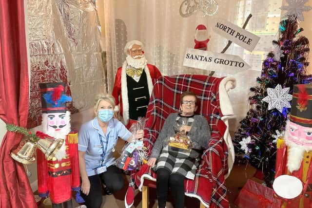 Assistant unit manager Tanya Fletcher giving a Christmas present donated by Virgin Media to 75-year-old Shearwater care home resident Mary. 
Picture: Shearwater care home