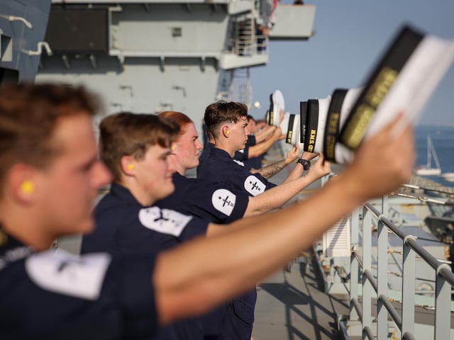 Pictured : HMS Queen Elizabeth's company lining the upper deck.