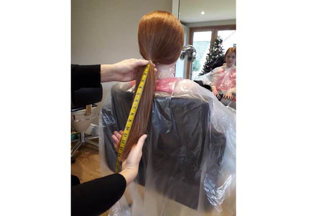 Lily Torah, 10 from Cowplain, had her hair cut short for the Little Princess Trust and raised more than £1,000. Pictured: Lily's hair being measured before chopping it off