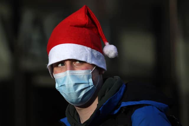 A shopper in a santa hat and wearing a face covering. Picture: HOLLIE ADAMS/AFP via Getty Images