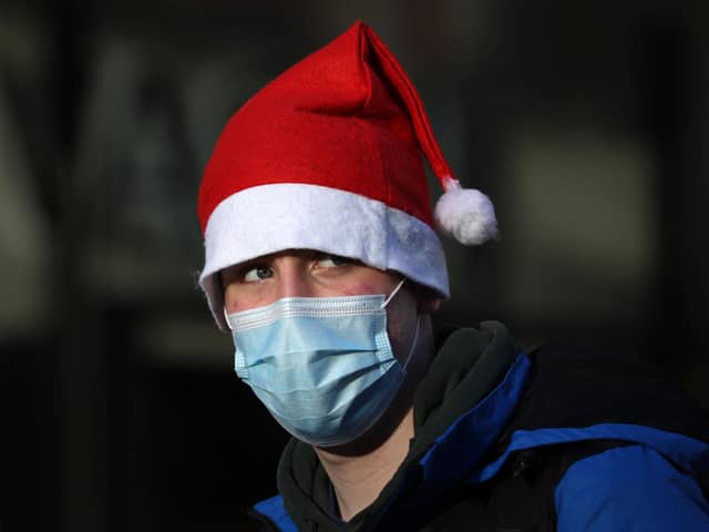 A shopper in a santa hat and wearing a face covering. Picture: HOLLIE ADAMS/AFP via Getty Images