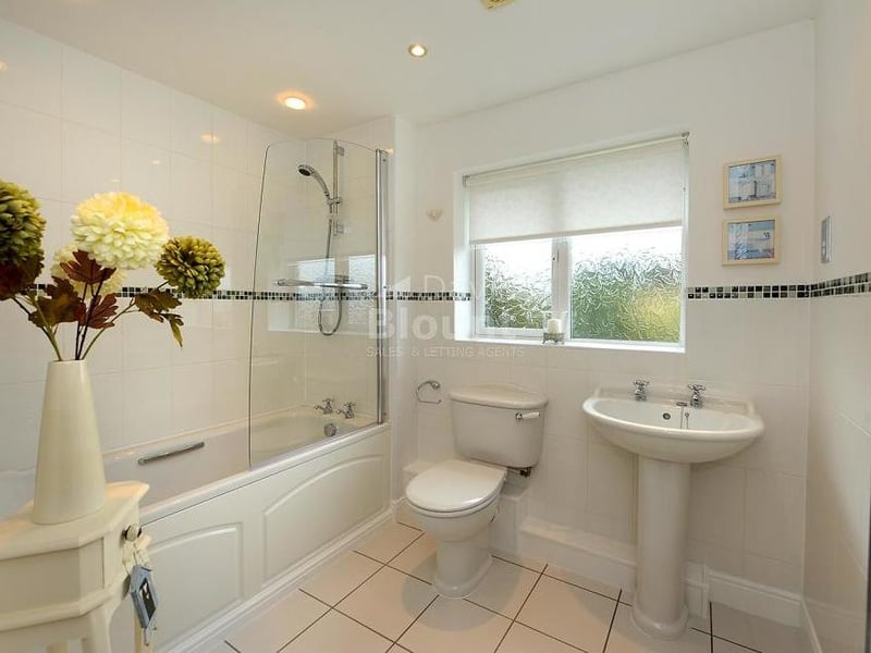 Here is the family bathroom, which consists of a panelled bath, wash hand basin and WC. There is a mains shower above the bath, while a chrome radiator adorns the wall.