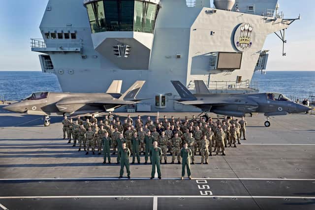 Personnel from 207 Squadron pictured on the flight deck of HMS Prince of Wales with two F-35 stealth jets in the background. The squadron had been embarked on the carrier for two week. Photo: Royal Navy.