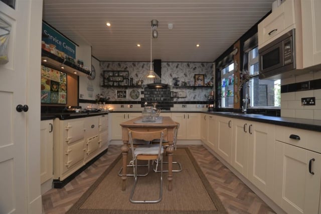 The open plan kitchen features an electric oven and gas hob as well as an AGA stove, extensive refitted units and work surfaces.