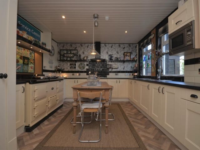 The open plan kitchen features an electric oven and gas hob as well as an AGA stove, extensive refitted units and work surfaces.