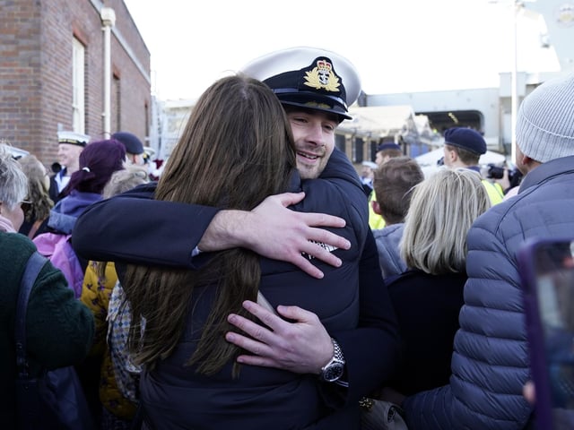Midshipman Joshua Wood hugs his partner after the Royal Navy aircraft carrier HMS Prince of Wales returns to Portsmouth Naval Base following it's three-month deployment to the Eastern Seaboard of the United States, where the Prince of Wales has been undergoing trials and operating with aircraft and drones. Picture: Andrew Matthews/PA Wire.