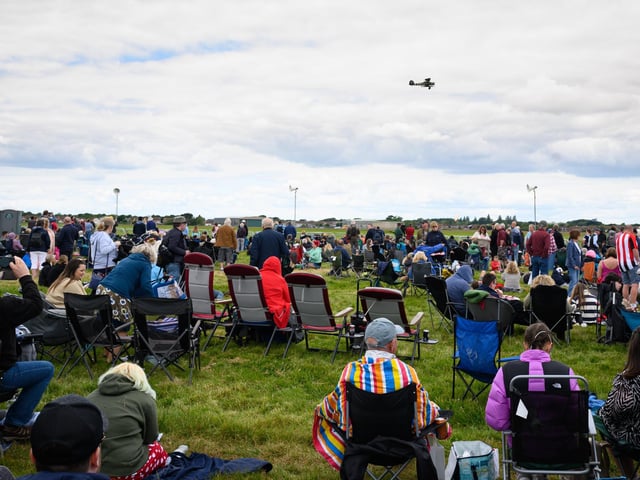 Pictured is: Visitors to the show watch and aircraft displayPicture: Keith Woodland (080621-105)