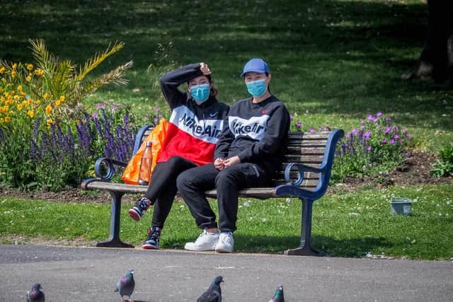 People sitting on a bench at Canoe Lake wearing masks.  Picture: Habibur Rahman