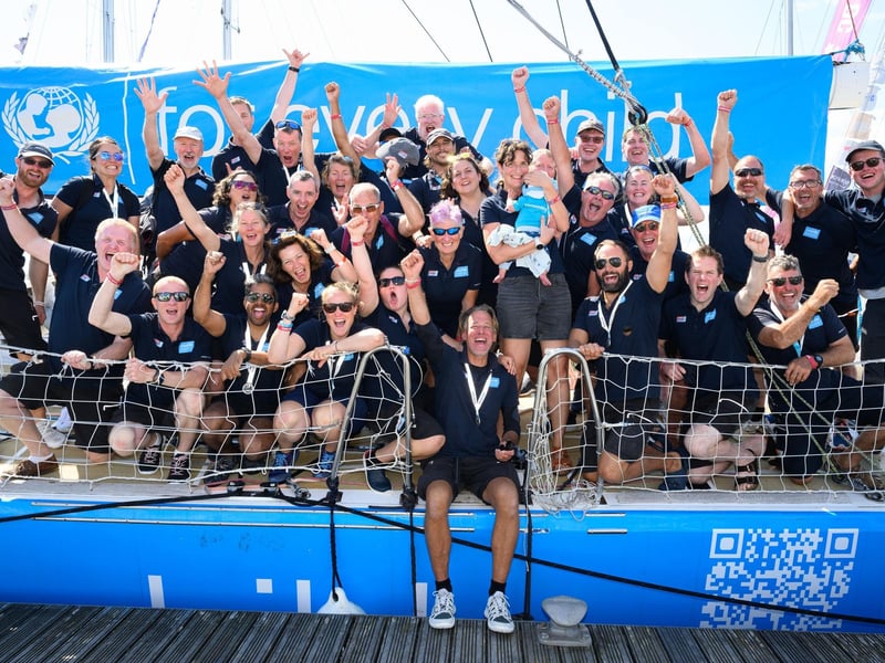 The UNICEF crew celebrate returning as one member holds a new addition to the team.Picture: Keith Woodland (270721-98)