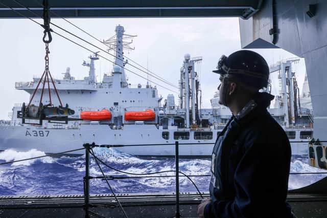 A HMS Queen Elizabeth crew member watches as highly explosive ordnance is brought onboard. Picture: Royal Navy