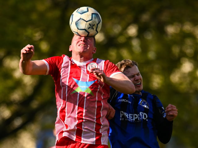 Clanfield's Olly Long, right, is beaten in the air. Picture by Richard Murray