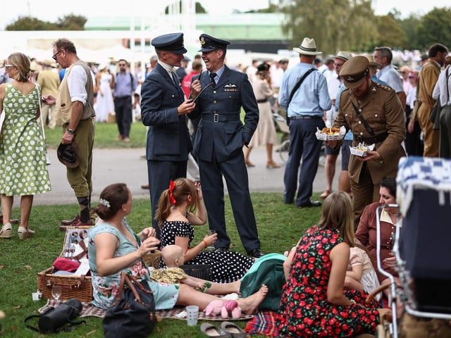 People wearing period clothing attend the opening day of Goodwood Revival at the Goodwood Motor Circuit in Chichester on September 8, 2023. The only historic motor race meeting to be staged entirely in a period theme, Goodwood Revival is an immersive celebration of iconic cars and fashion. (Photo by HENRY NICHOLLS / AFP) (Photo by HENRY NICHOLLS/AFP via Getty Images)