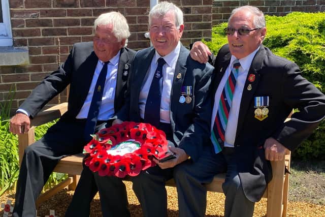 Three veterans pictured sitting on the bench honouring the sailors who lost their lives during the sinking of HMS Coventry.