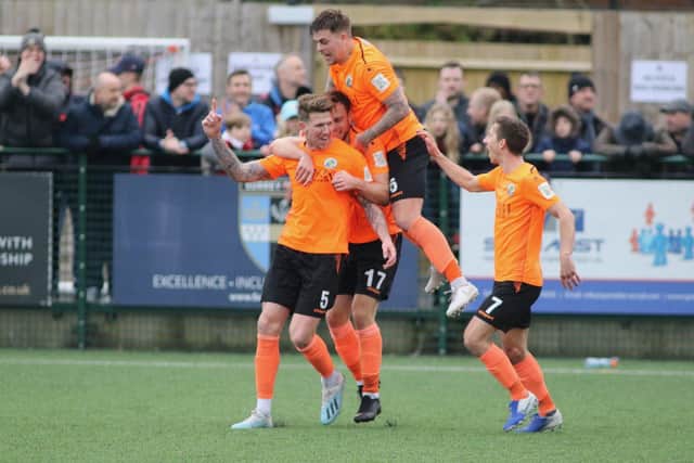 Hawks players mob Dean Beckwith after his dramatic late winner at Dorking in March 2020, the last time the two clubs met. Picture: Kieron Louloudis