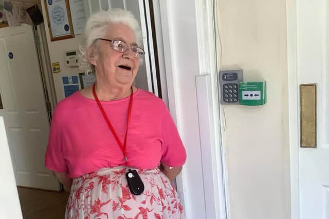 A Hartwell Lodge resident watches through the front door with a smile as Jennifer Parker-Lummis performs in the car park. Picture: Hartwell Lodge