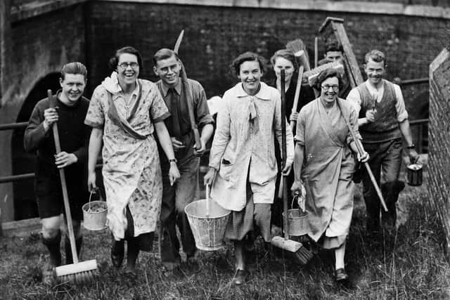 A group of people setting off with brooms and buckets to clean up Fort Purbrook on Portsdown Hill in April 1937. Picture: Getty