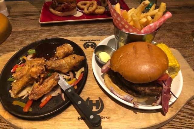 The burger sizzler combo - a double bacon cheeseburger, chicken wings and a rump steak with barbecue sauce on a skillet of onions and peppers