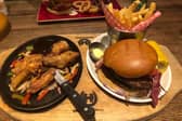 The burger sizzler combo - a double bacon cheeseburger, chicken wings and a rump steak with barbecue sauce on a skillet of onions and peppers