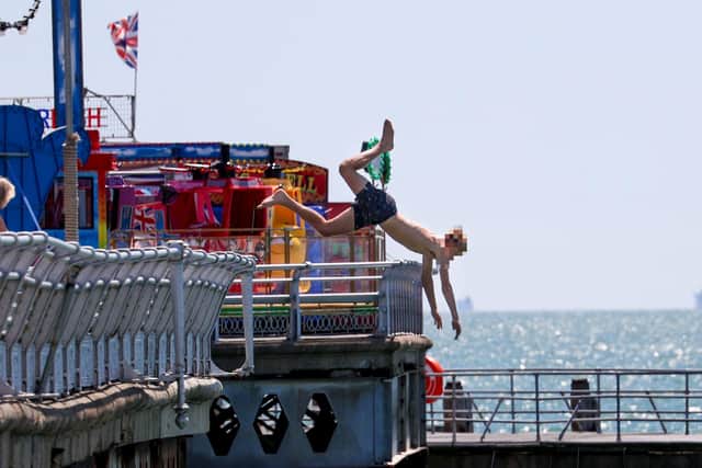 Head-first: a youngster performs a dangerous dive from South Parade Pier despite safety pleas from the RNLI and pier maintenance staff. 
Photos by Alex Shute