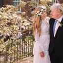 In this handout image released by 10 Downing Street, Prime Minister Boris Johnson poses with his wife Carrie Johnson in the garden of 10 Downing Street following their wedding at Westminster Cathedral, May 29, 2021 in London, England. Photo by Rebecca Fulton / Downing Street via Getty Images.