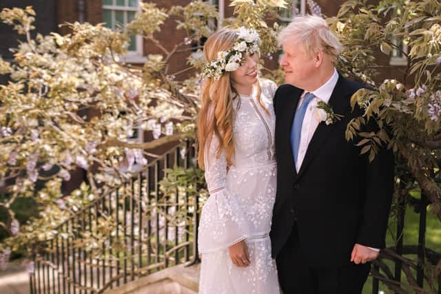 In this handout image released by 10 Downing Street, Prime Minister Boris Johnson poses with his wife Carrie Johnson in the garden of 10 Downing Street following their wedding at Westminster Cathedral, May 29, 2021 in London, England. Photo by Rebecca Fulton / Downing Street via Getty Images.
