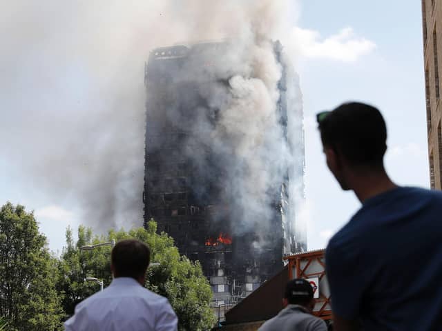 Pedestrians look up towards Grenfell Tower in London on June 14, 2017, as firefighters continue to control the fire that engulfed the building in the early hours of the morning. Picture: Adrian Denniss/AFP via Getty Images.