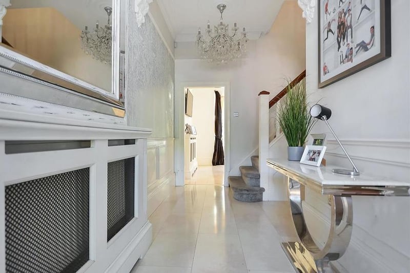 Another view of the elegant entrance hall. It features a door to the cellar and stairs to the first-floor landing.