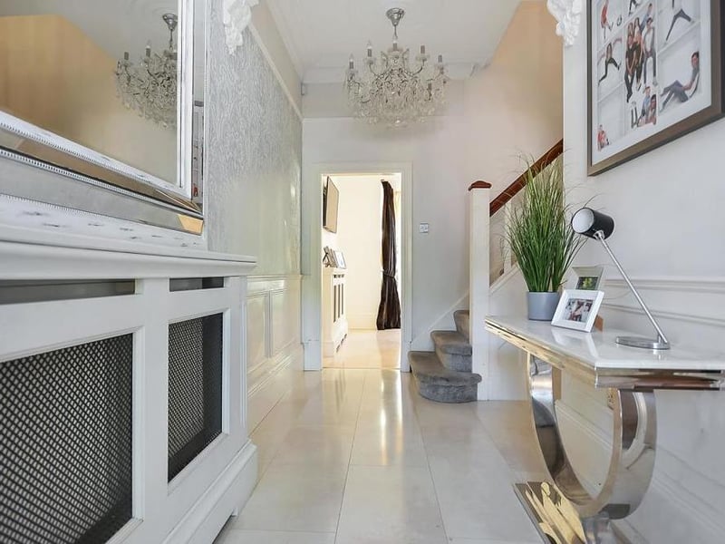 Another view of the elegant entrance hall. It features a door to the cellar and stairs to the first-floor landing.